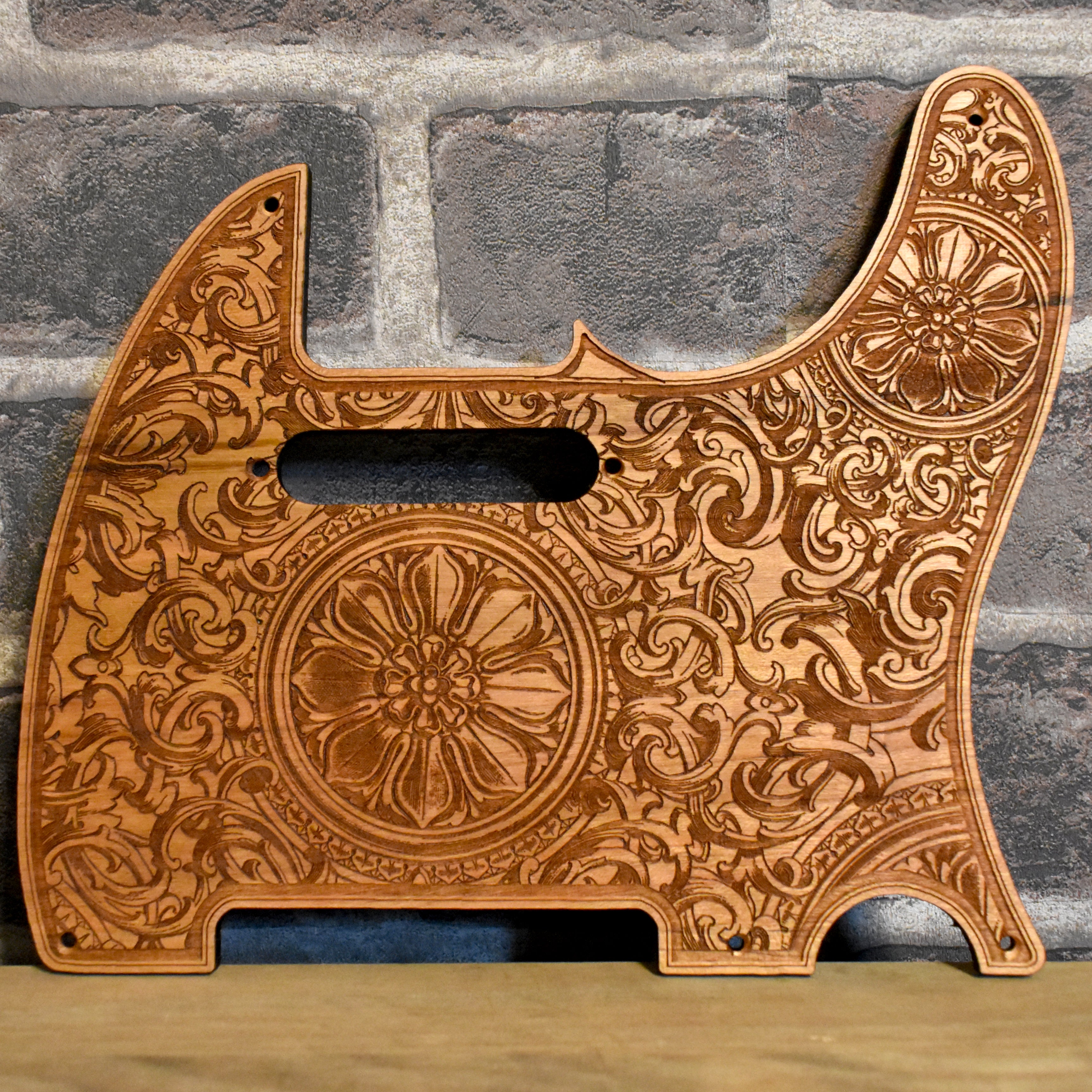 Floral wood pickguard for Telecaster electric guitar, hand-engraved design.