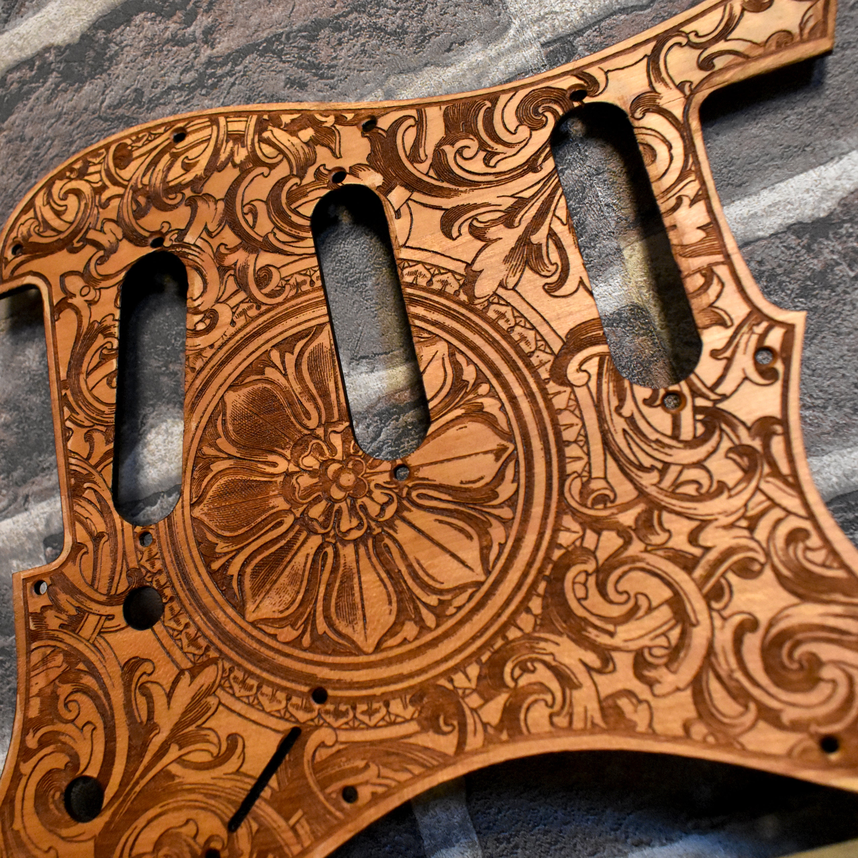 Handcrafted wooden pickguard with intricate floral engraving, fits Strato-style guitars.