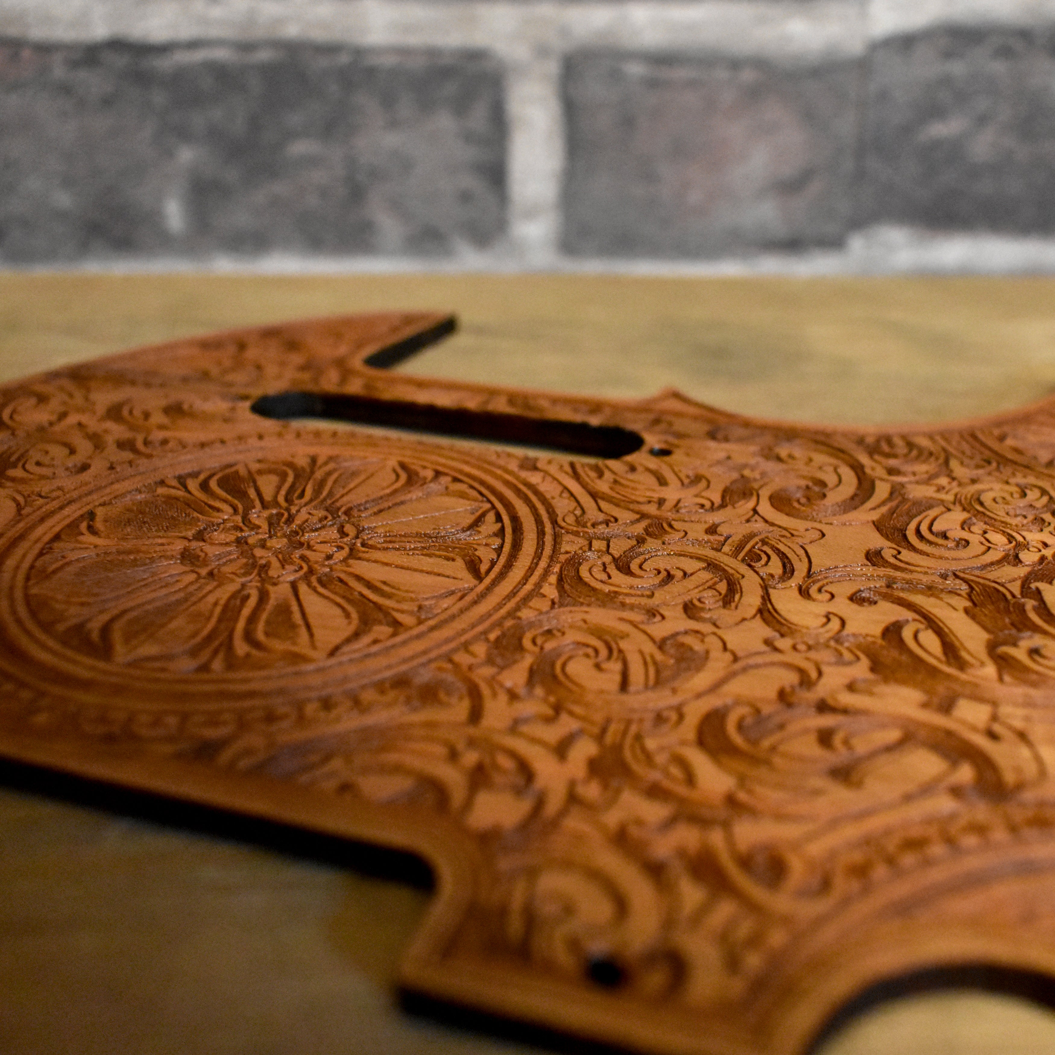 Handcrafted Telecaster pickguard featuring intricate floral wood engraving.