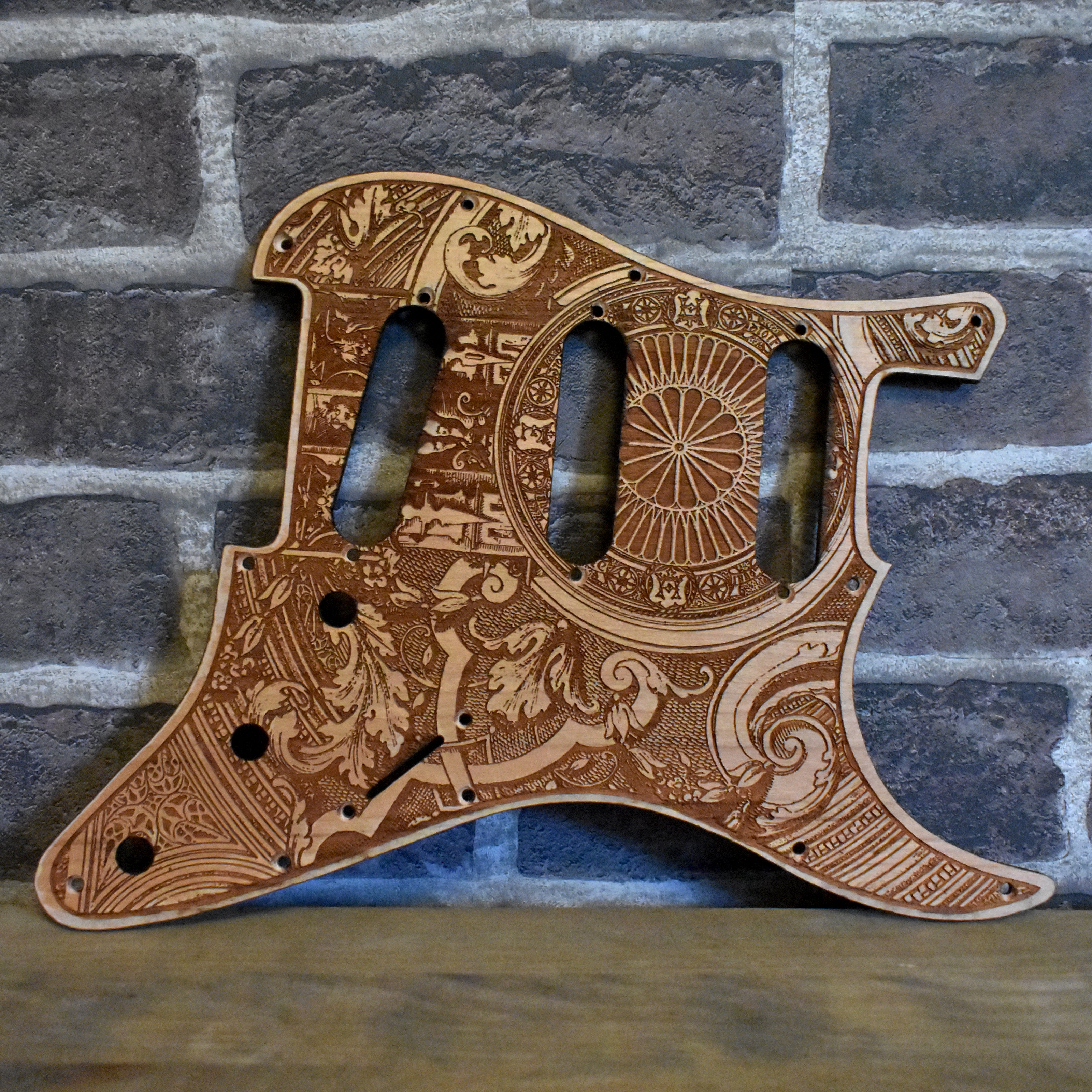 Handcrafted cherry wood pickguard for Fender Stratocaster with laser-engraved gothic design