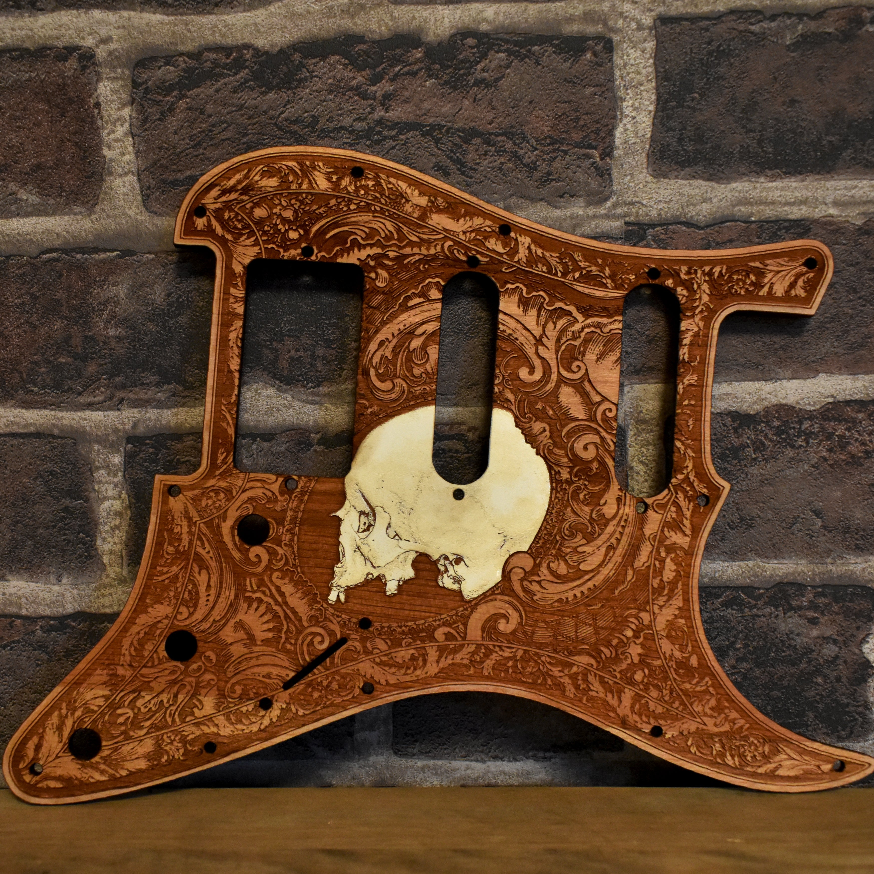 Fender Stratocaster cherry wood pickguard with laser-engraved skull design, handmade.