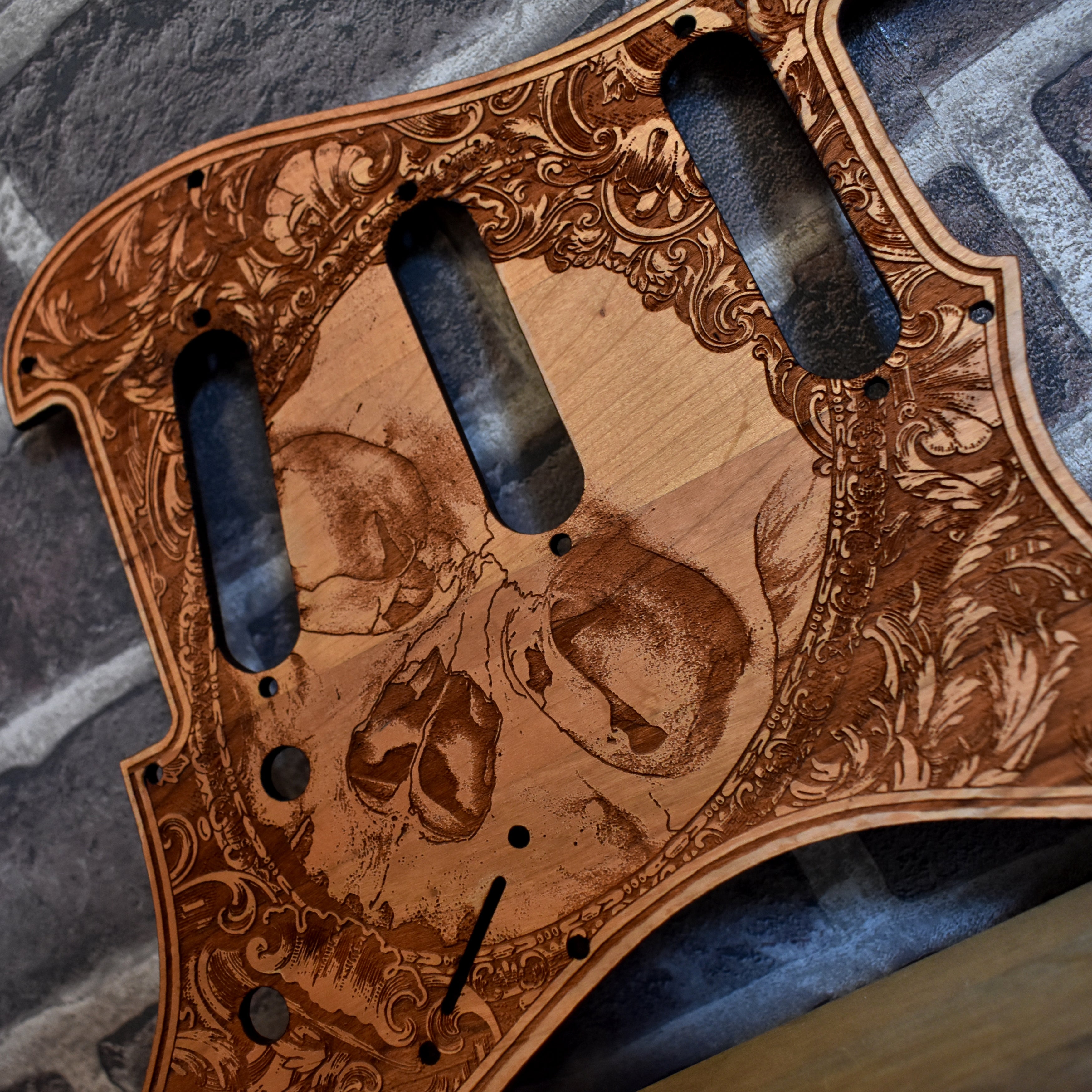 Close-up of laser-engraved artwork on cherry wood pickguard for Fender Stratocaster, HSS & SSS compatible.