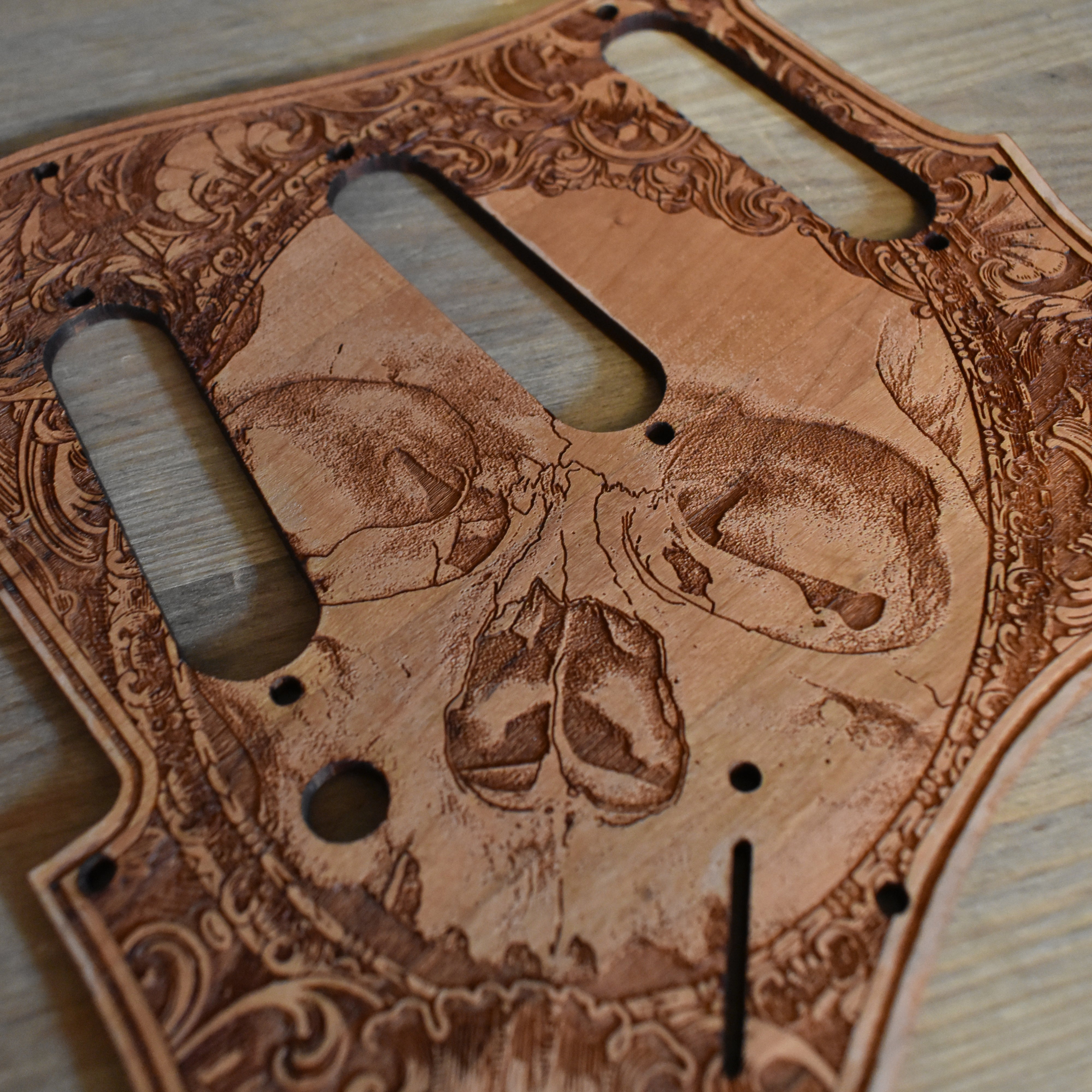 Hand-polished cherry wood pickguard featuring intricate laser engraving for Fender Stratocaster guitars.