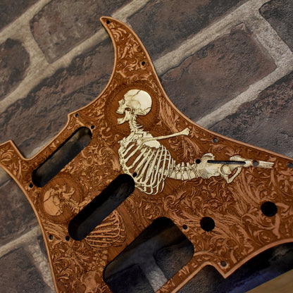 Close-up of handcrafted cherry wood pickguard with intricate laser engraving for Fender Stratocaster.