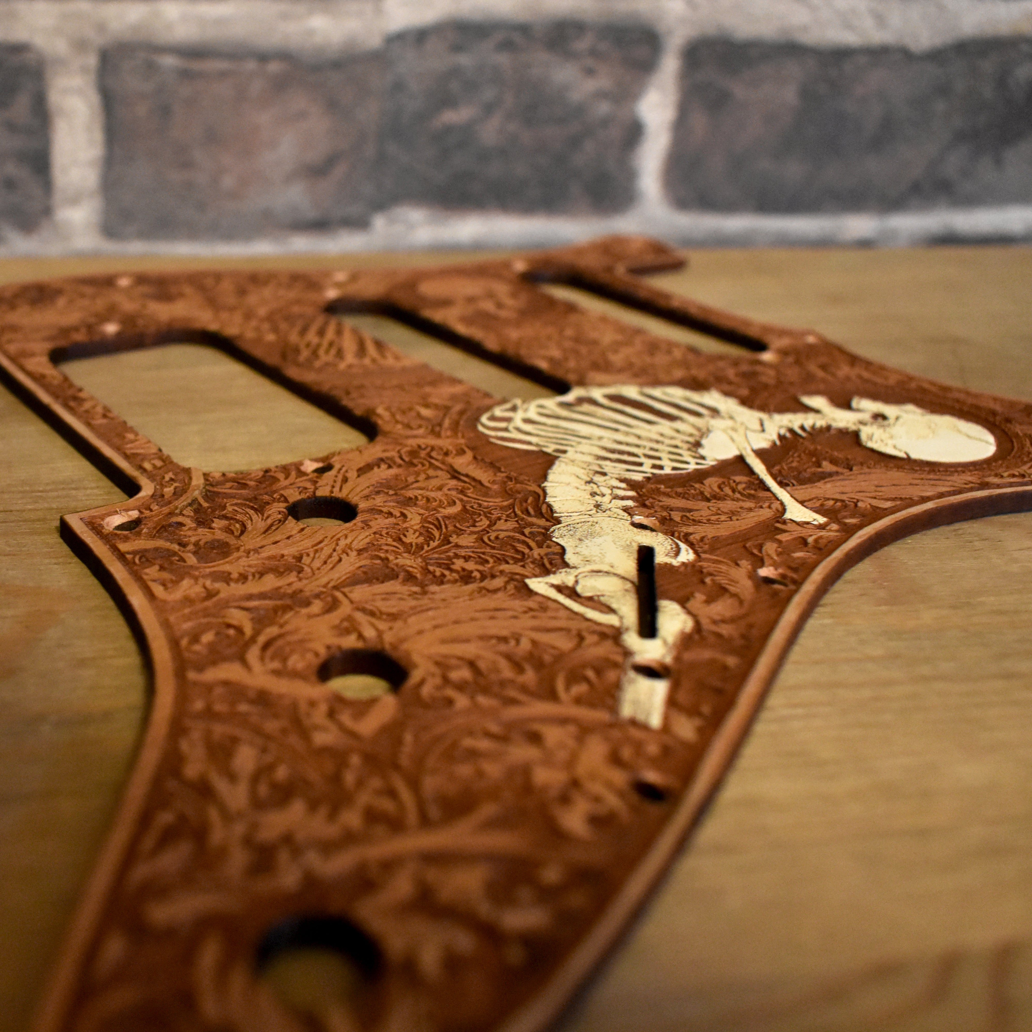 Hand-finished cherry wood pickguard showcasing detailed laser engraving for Fender Stratocaster guitars.