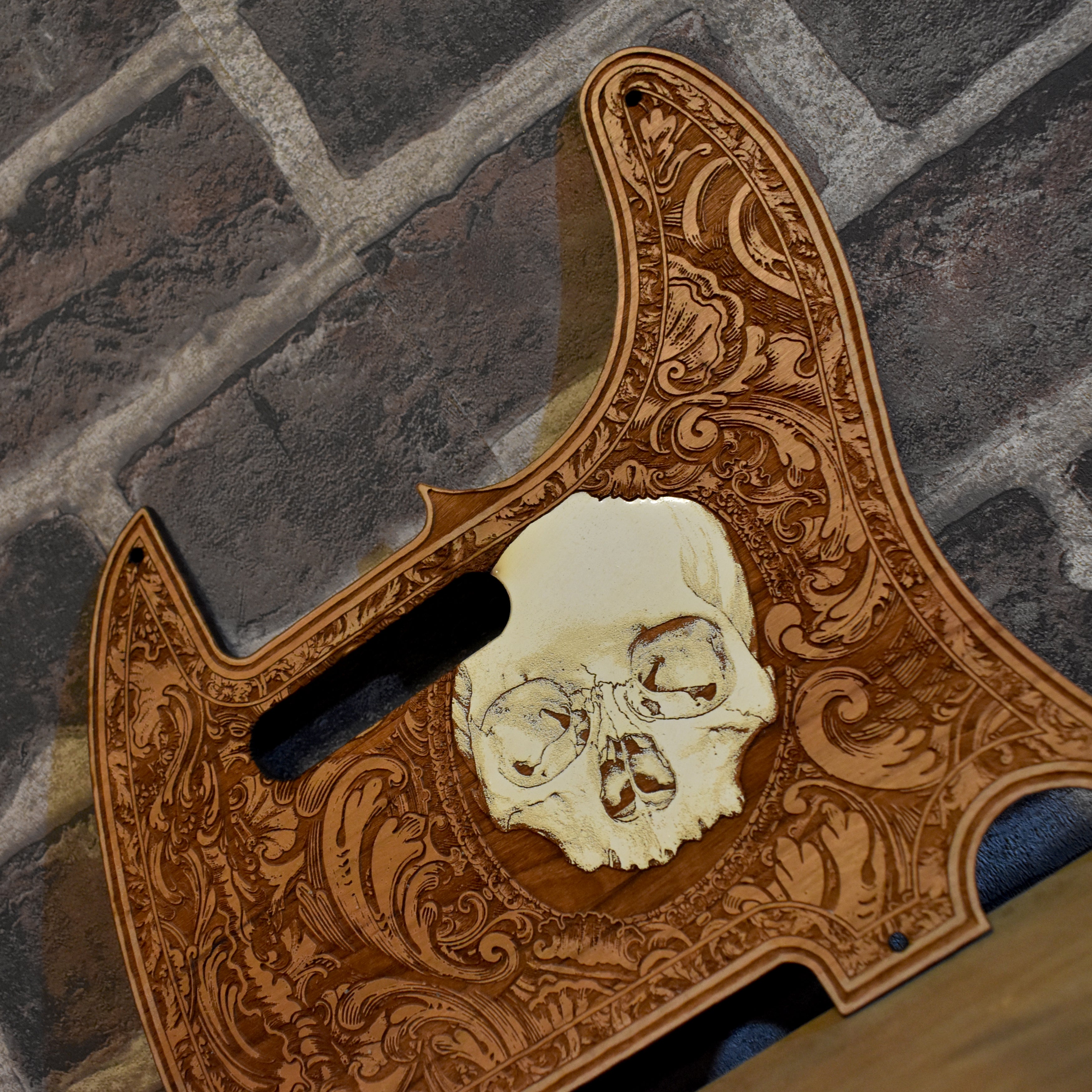 Close-up of intricate laser engraving on cherry wood pickguard for Fender Telecaster