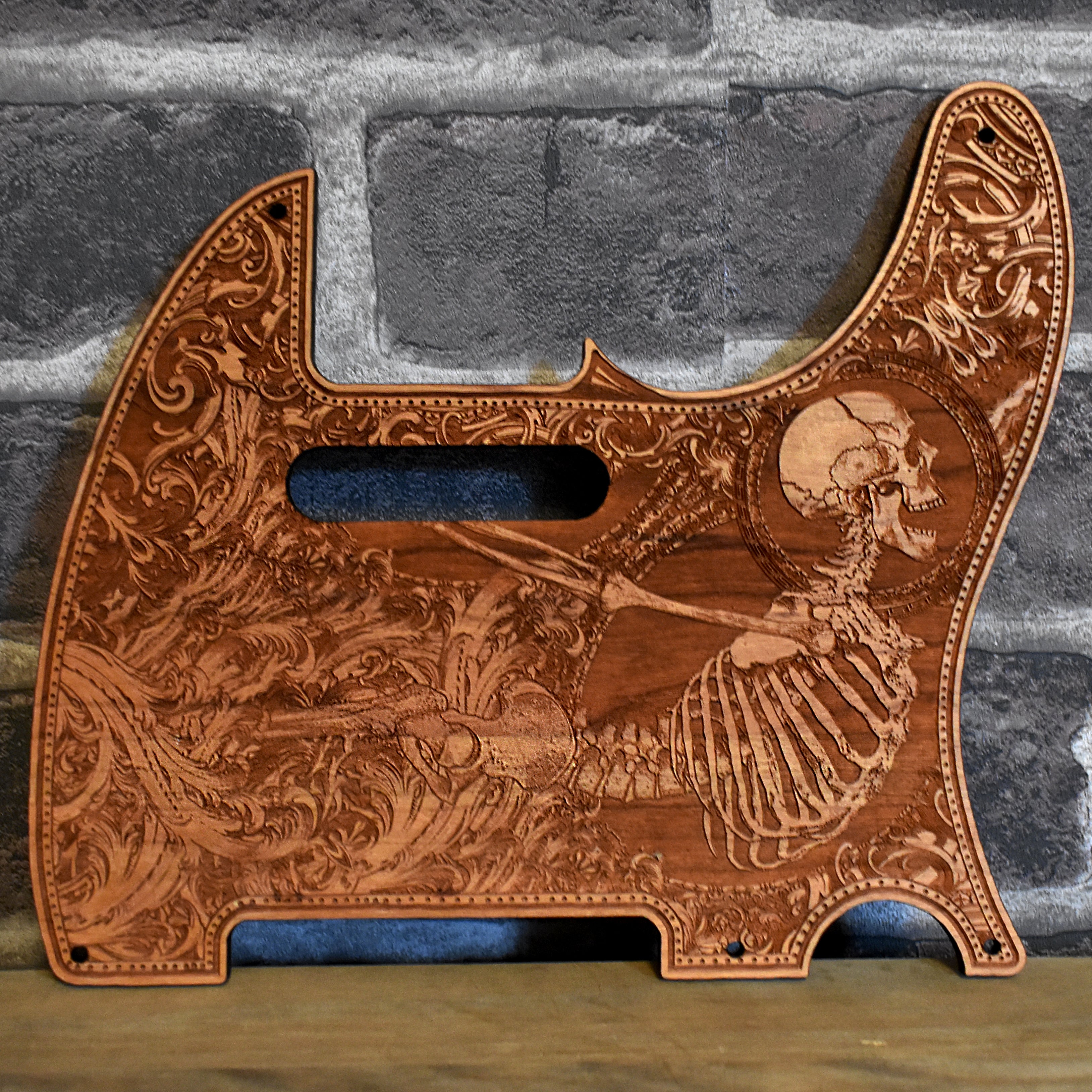 Fender Telecaster cherry wood pickguard with laser-engraved skeleton art.