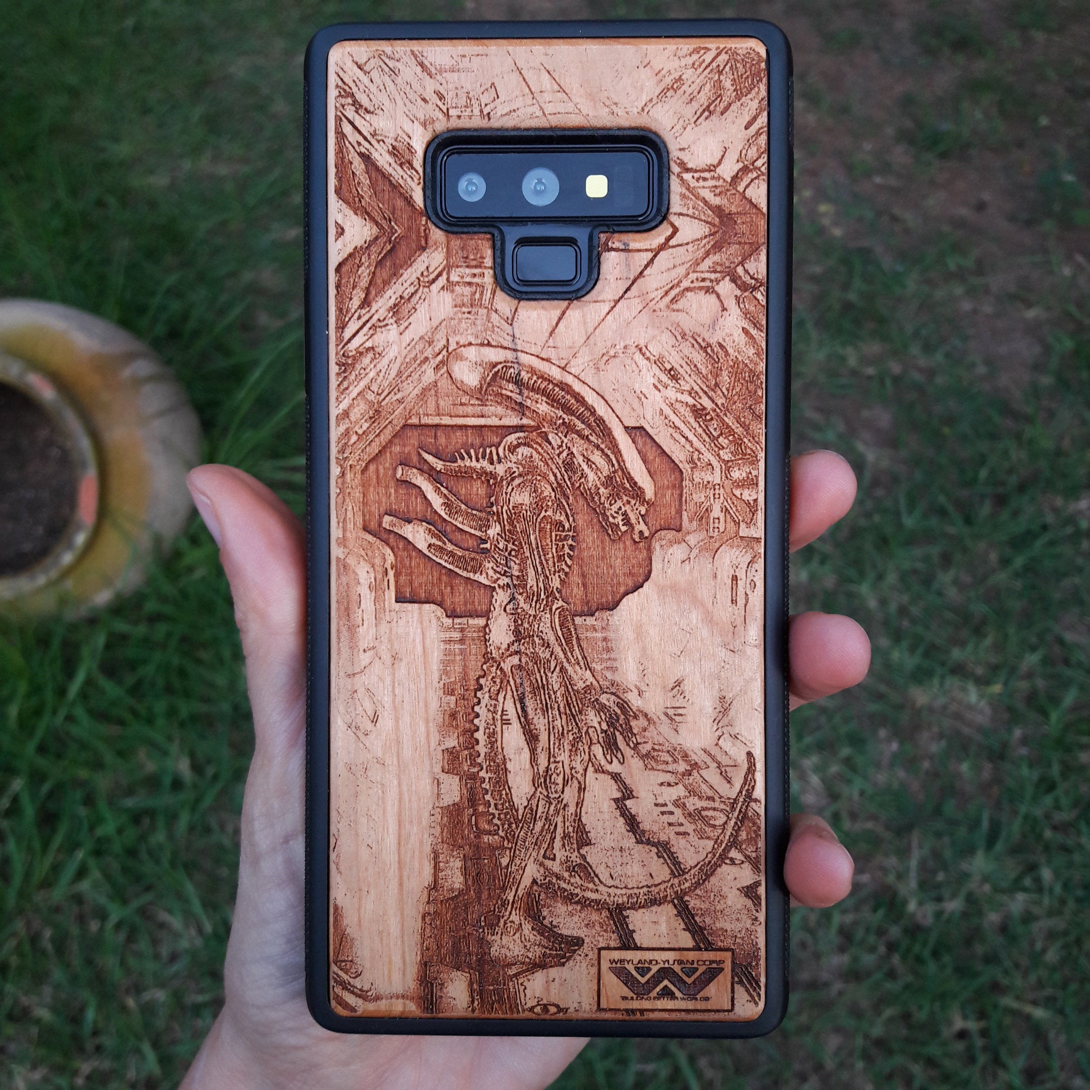 Wooden Xenomorph phone case with intricate HR Giger-inspired design, compatible with iPhone 16, iPhone 15, Galaxy S25, and more. Perfect for Alien movie fans and sci-fi lovers.